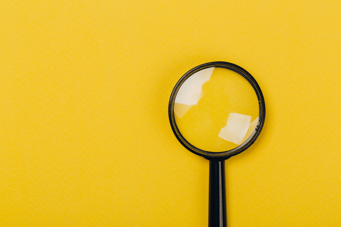 Small magnifying glass on yellow background, search symbol